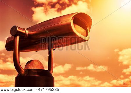 A Picture Of Steel Binoculars Over Light Sky And Clouds