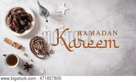 Ramadan Food And Drinks Concept. Ramadan Arabian Lamp, Wood Rosary, Tea, And Dates Fruit On Stone Ba