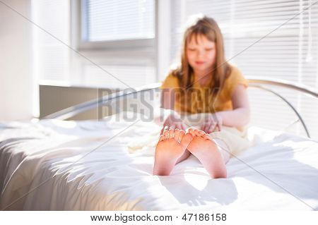 Dívka sedící na posteli