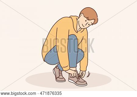 A Little Boy Ties A Shoelace On His Shoe. Childrens Clothing For Walking, Training In Tying Shoes, T