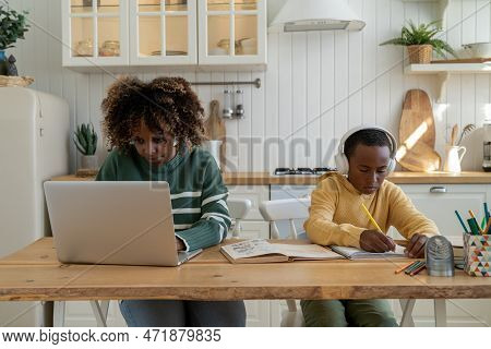 Concentrated Woman Look Laptop Screen Work Remotely From Home Next To Schoolboy Son Preparing Creati