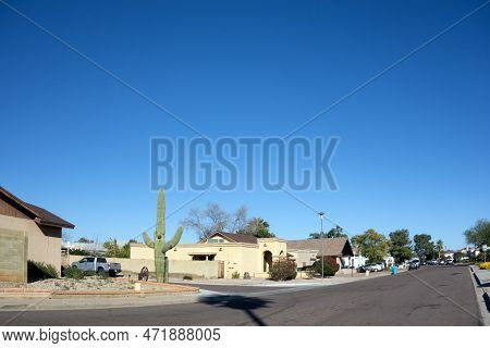 Phoenix, Az - February 25, 2023: Classic Arizona Branching Saguaro And Rusty Old Cart Wheel At Xeris