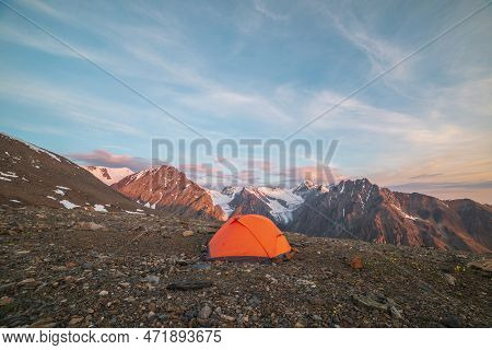 Awesome Landscape With Vivid Orange Tent With View To High Snow Mountains In Sunrise Colors. Colorfu