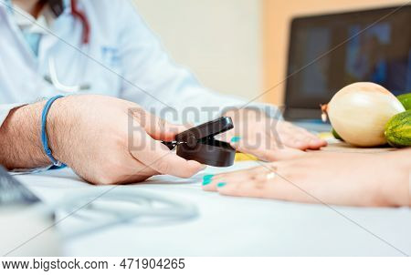 Hand Of Nutritionist Using Oximeter On Finger Of Female Patient. Close Up Of Hands Of Nutritionist U