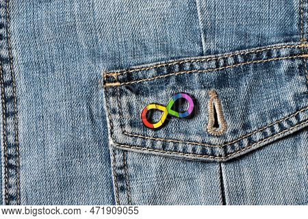 World Autism Awareness Day. Closeup View Of Denim Jacket With Metallic Pin Brooch. Autism Infinity R