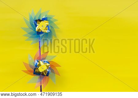 Wind Turbine Or Windmill Handmade Plastic Children's Colorful Toy Isolated On Yellow Background
