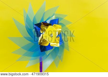 Wind Turbine Or Windmill Handmade Plastic Children's Colorful Toy Isolated On Yellow Background