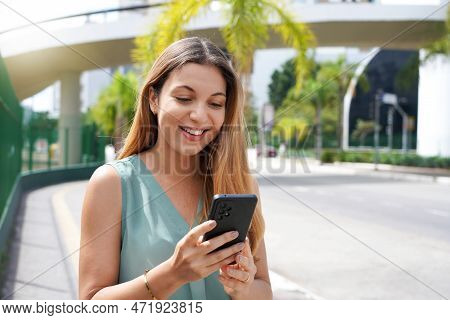 Close-up Of Happy Woman In City Using Ovp Or Social Media Platform On Smartphone