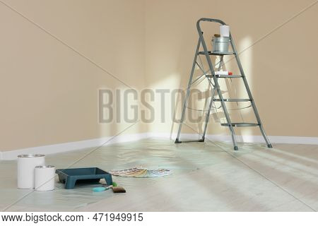 Stepladder And Painting Tools Near Wall In Empty Room, Space For Text