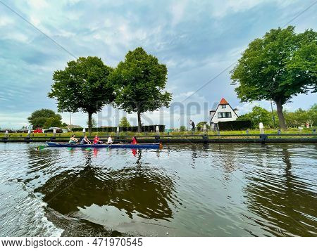 Voorburg, Netherlands - June 19 2022: A Rowing Boat With Women Rowing Peddles In A Canal