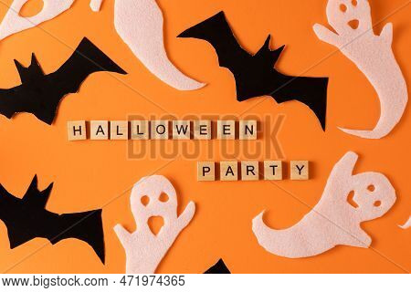 White Ghosts And Bat Craft For Halloween Party. Wrapping Paper Ghost On Orange Background Top View. 