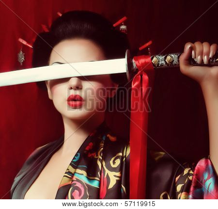 Beautiful geisha in kimono with samurai sword