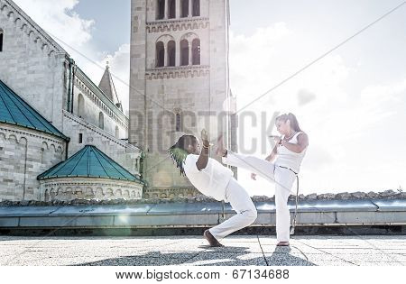 Pair of capoeira performers doing a kicking