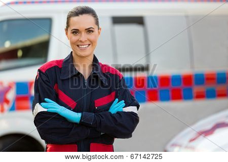 beautiful female paramedic with arms crossed in front of ambulance