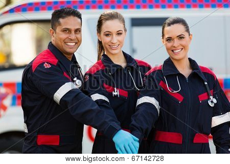 group of paramedics hands together in front of ambulance