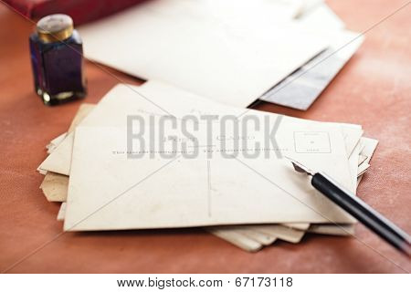 retro photo post cards , vintage ink , pen, blotter and camera on old leather table