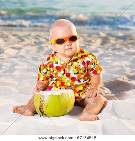 Funny baby wearing sunglasses with coconut