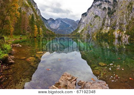 Cloudy day on the lake. Magic reflection in German lake Koenigssee. Clouds and mountains reflected in the mirrored surface of the water