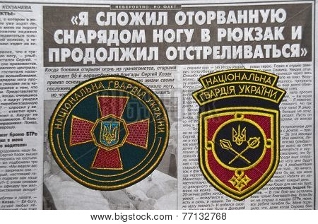 Kiev,Ukraine.Oct 16.Illustrative editorial.Ukranian National Guard  chevrones .Newspaper with heroic story of soldier as background.At October 16,2014 in Kiev, Ukraine 