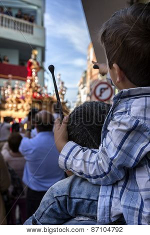Child Of Backs With Ramrod Of Drum In His Hand With His Father During Holy Week Procession, Spain