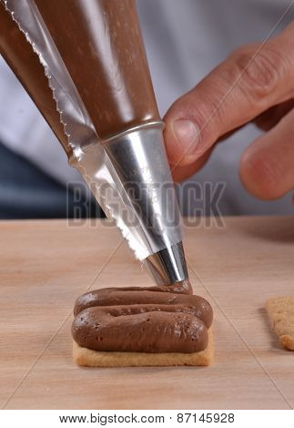 Cook preparing nuts cream cookies.