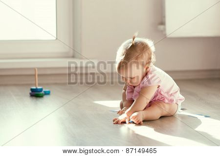 Little Girl Playing With Pyramid On Floor