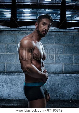 Portrait of a Handsome Muscular Man Wearing Boxer Brief Standing Inside an Old Building While Looking at Camera.