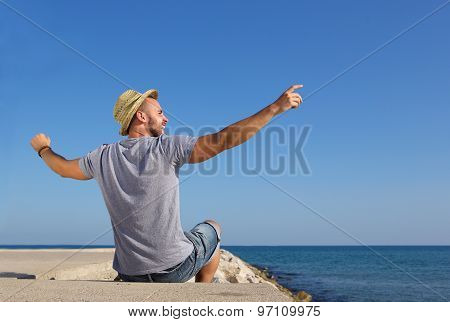 Man Sitting By The Sea With Arms Spread Open