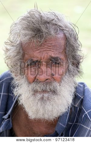 Sri Lankan beggar waits for alms on a street next to the bus station