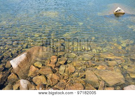 Clear Water And Stones In Lake In Mountains.