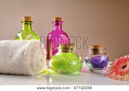 Oils And Bath Salts On White Glass Table