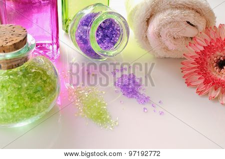 Oils And Bath Salts Reflected On White Glass Table