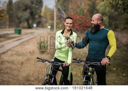 Couple Of Cyclists Resting In Park