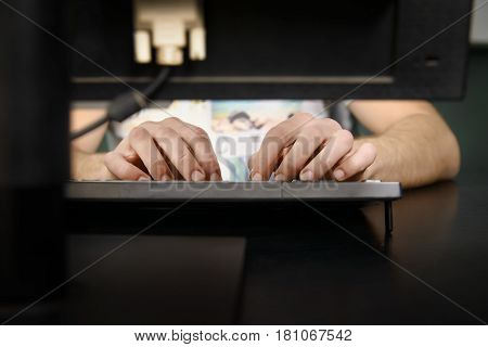Image of male hands typing on computer keyboard