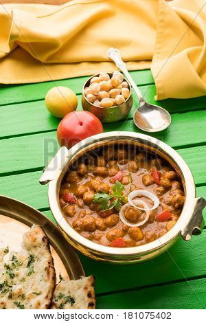 spicy chick peas curry or Chola Masala or Chana Masala or chole bhature or choley garnished with sliced onion and green coriander leaf, selective focus