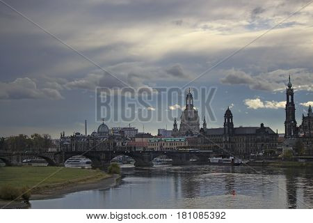 View from the river towards the old town in Dresden against the backdrop of dramatic sky