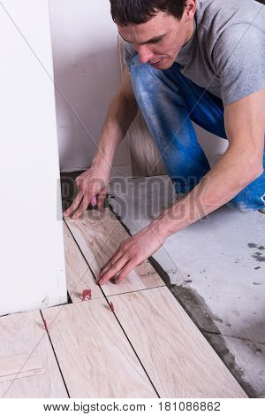 Tiler installing ceramic tiles on a floor