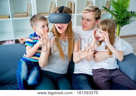 Happy family at home and playing with virtual reality goggles, VR headset, modern technology glasses