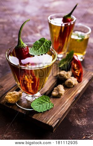 Transparent alcoholic drink with red pepper. Selective focus.