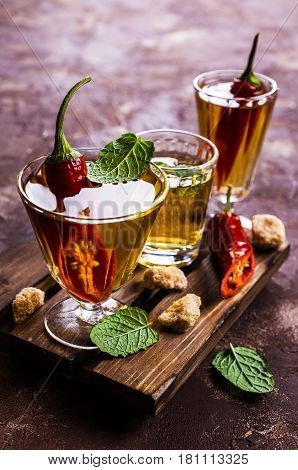 Transparent alcoholic drink with red pepper. Selective focus.