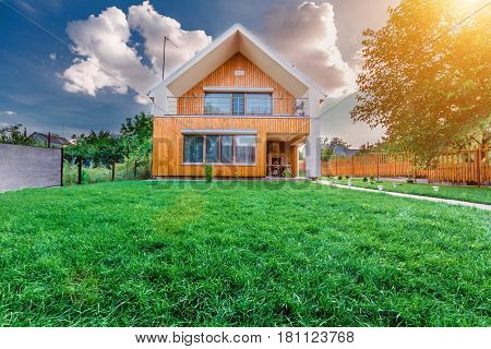 Modern summer cottage against a blue sky in the summer garden. Sunny day