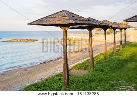 Decorative umbrellas made of palm branches on the background of the beach.