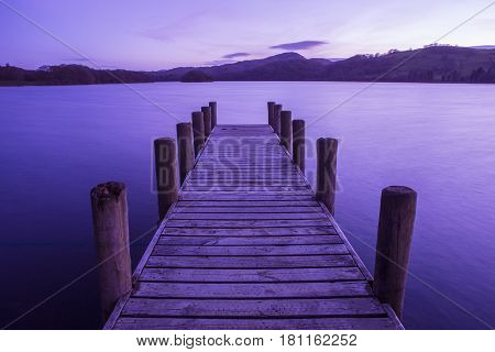 An evening view of a jetty on Coniston Water in the Lake District in Cumbria UK.