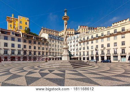 Town Hall Square with a beautiful geometric mosaic in Lisbon, Portugal. In the center of the square the pillory The Pelourinho de Lisboa