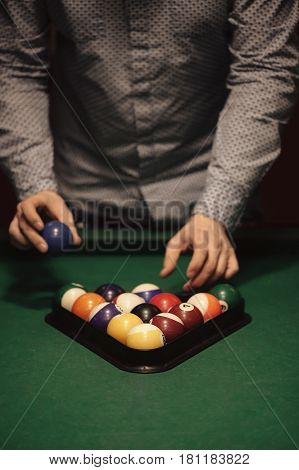 American billiard poule. Triangle of billiard balls. A man getting ready to start a game of billiards.