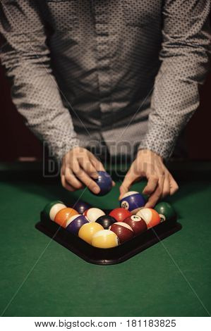 American billiard poule. Triangle of billiard balls. A man getting ready to start a game of billiards.