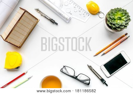 profession concept with architect desk and constructor tools with phone on white background top view mock-up
