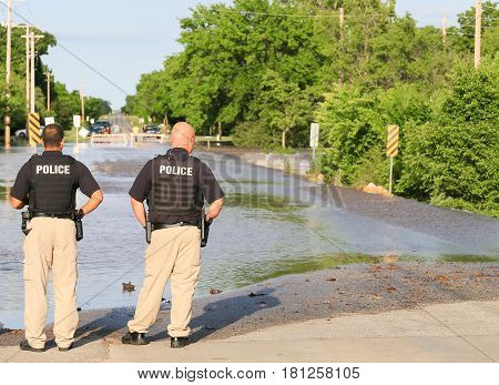 Policemen At A Flooded Street