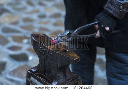 Metal fabricator utilizing a torch to heat up a piece of metal in order to shape it utilizing a forging technique developed over hundred years ago.