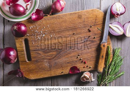 Red Onion Bulb On Brown Cutting Board.